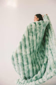 Model wrapped in the Extreme Ultra Cloud Malachite Green Blanket, showcasing its plush texture and cozy design.