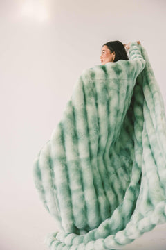 Model wrapped in the Extreme Ultra Cloud Malachite Green Blanket, showcasing its plush texture and cozy design.