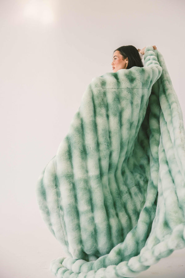 Model wrapped in the Extreme Ultra Cloud Malachite Green Blanket, showcasing its plush texture and cozy design.