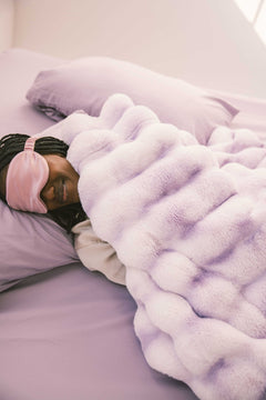 Cozy scene of a person resting under the Extreme Ultra Cloud Lilac Breeze weighted blanket, showcasing its plush comfort.