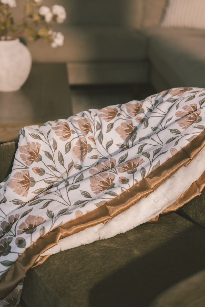 Garden floral-patterned blanket on a table with a blurred background.