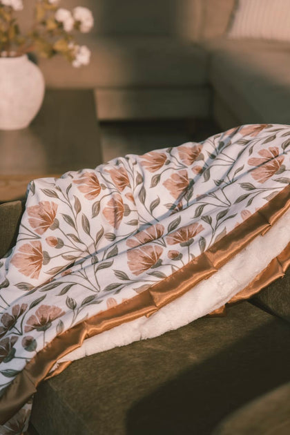 Garden floral-patterned blanket on a table with a blurred background.