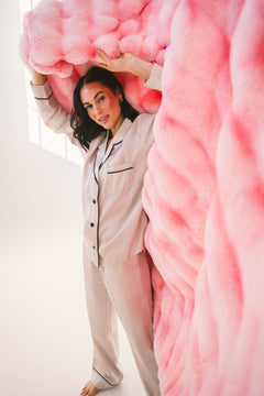Model showcasing the Extreme Ultra Cloud Pink Lemonade weighted Blanket in a cozy setting.
