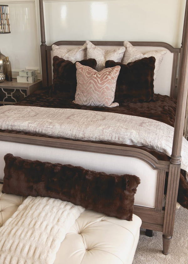 Bedroom with a four-poster bed and decorative pillows