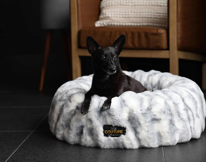 Minky Couture Cloudy Day Blue Pet Bed cover on a cozy pet bed with a black dog resting on it.
