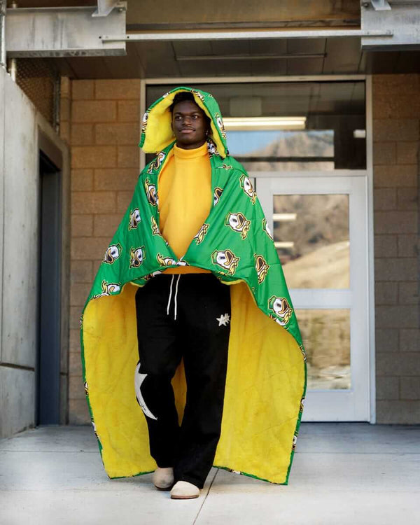 University of Oregon Ducks Hooded Stadium Blanket worn by a person outdoors, showcasing its vibrant colors and logo.