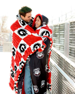 Hugs Georgia Bulldogs Blanket used by a couple, showcasing team spirit and cozy comfort on a chilly day.