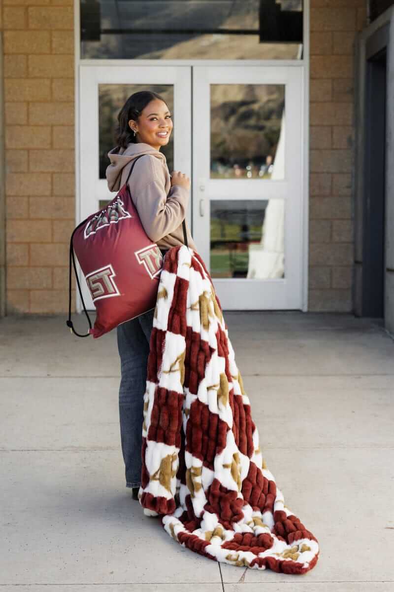Texas State Bobcats Hooded Stadium Blanket displayed by a woman outside, showcasing Bobcat pride and style.