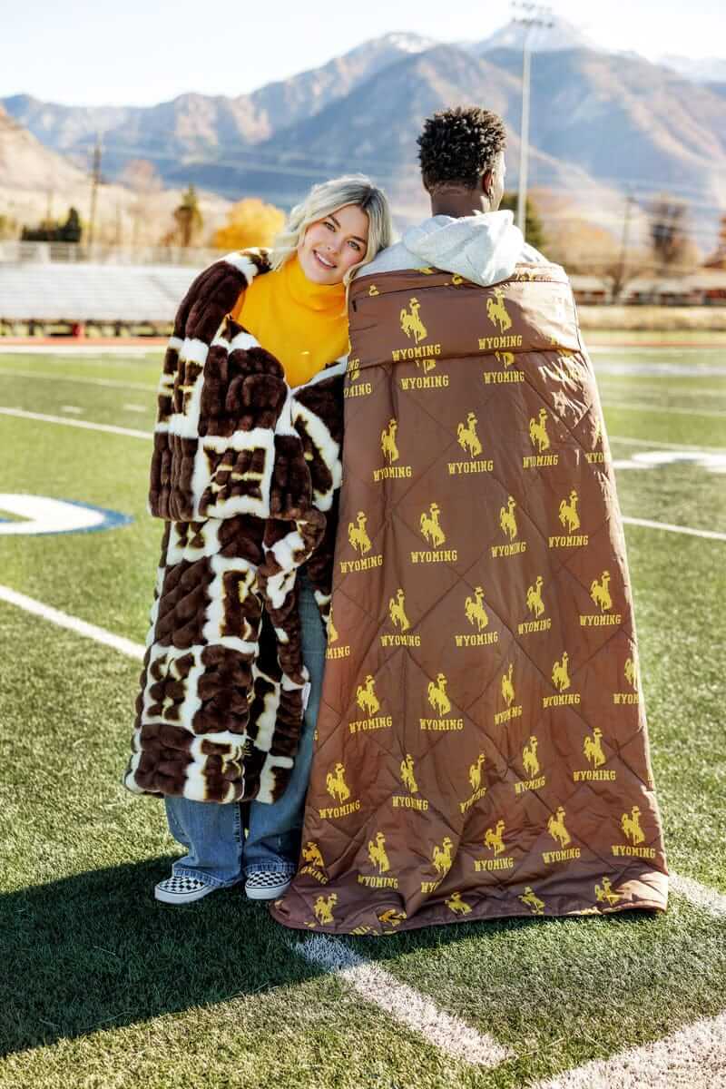 Wyoming Cowboys Hooded Stadium Blanket styled on models enjoying outdoor sports.
