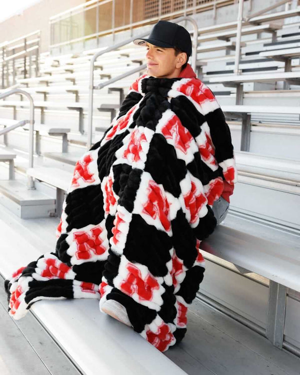Nebraska Huskers Blanket in bold black and white check pattern with bright red logos, perfect for fans.