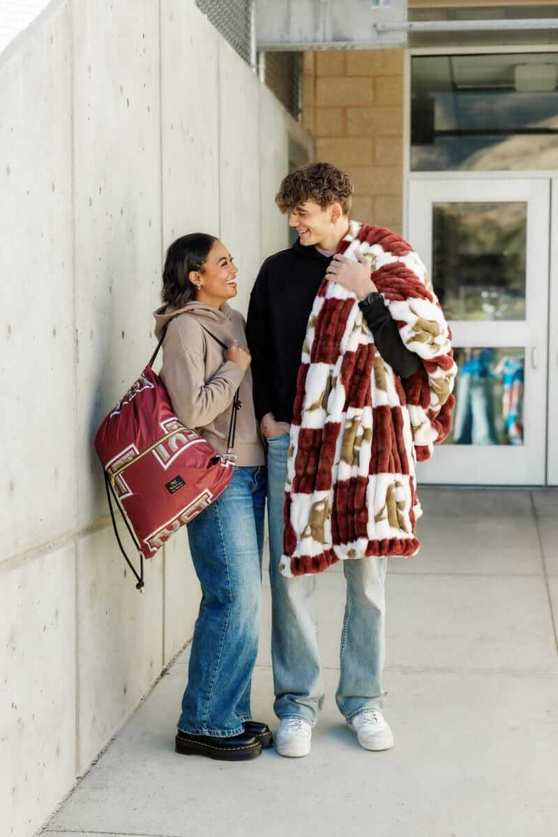 Minky Couture Texas State Bobcats Hooded Stadium Blanket being worn by two young adults in a casual setting.
