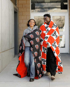 Texas Tech Raiders Hooded Stadium Blanket showcased by two friends wearing it outdoors.