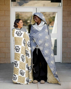 Hugs Colorado Buffaloes Blanket Cozy couple wearing CU themed blankets, showcasing team pride and comfort.