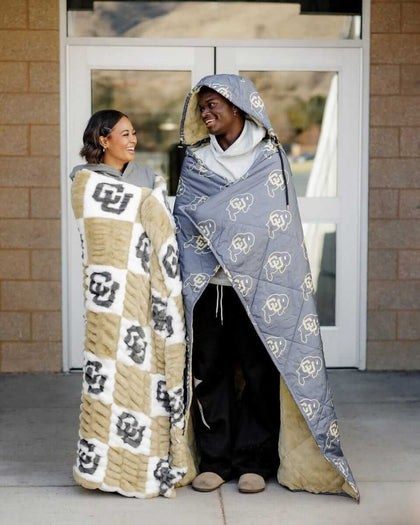 Hugs Colorado Buffaloes Blanket Cozy couple wearing CU themed blankets, showcasing team pride and comfort.