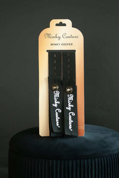 Minky Keepers product packaging showcasing two blanket-rolling straps by Minky Couture on a decorative stool.