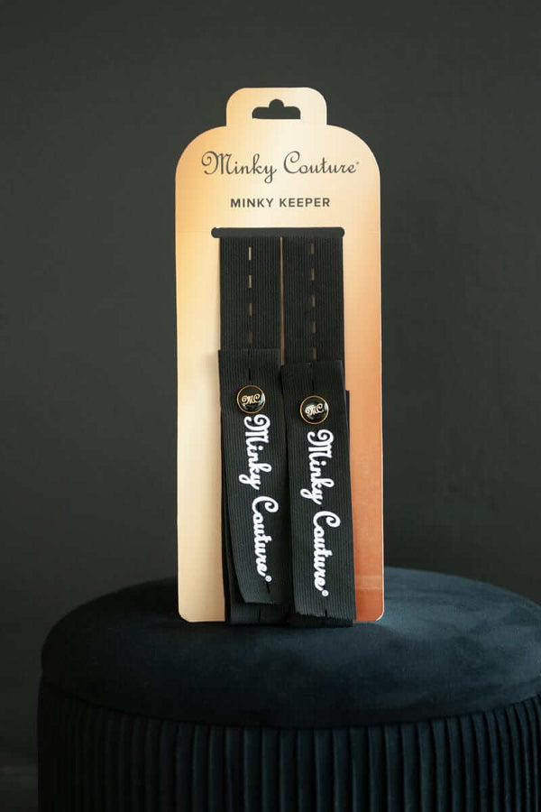 Minky Keepers product packaging showcasing two blanket-rolling straps by Minky Couture on a decorative stool.