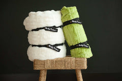 Minky Keepers set of two blankets neatly rolled in white and green, secured for storage.