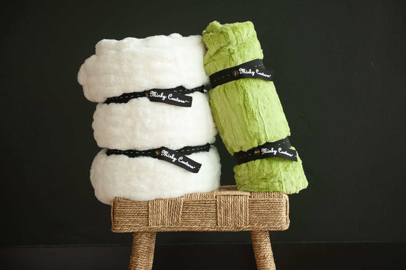 Minky Keepers set of two blankets neatly rolled in white and green, secured for storage.