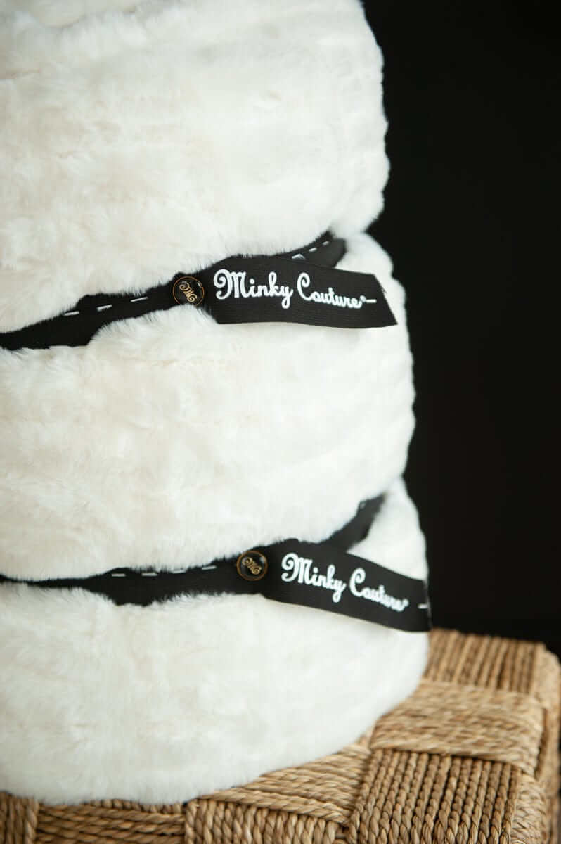 Minky Keepers holding rolled Minky Couture blankets, showcasing the innovative design for convenient storage.