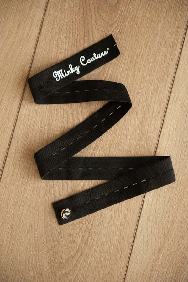 Minky Keepers design featuring innovative black straps for easy blanket rolling and storage on a wooden surface.