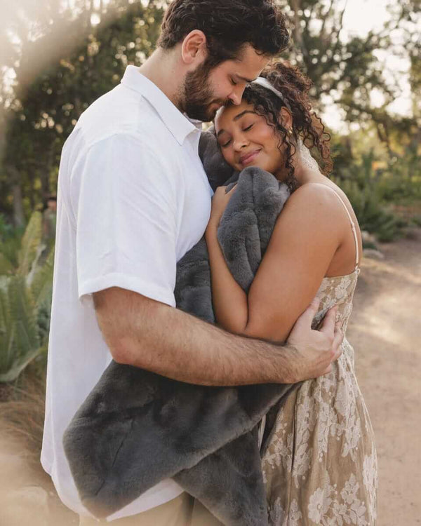 Couple embracing outdoors while wrapped in Lush Steel Gray Blanket, showcasing comfort and elegance.