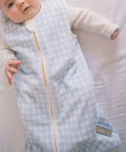 Dusty Blue Gingham Wearable Minky Couture Blanket on an infant, designed for safe and cozy sleep.