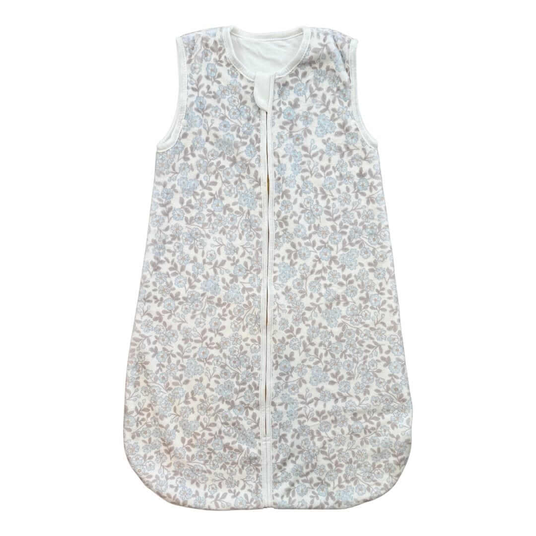 Sleeveless baby sleep sack with a soft floral print in light blue and taupe tones.