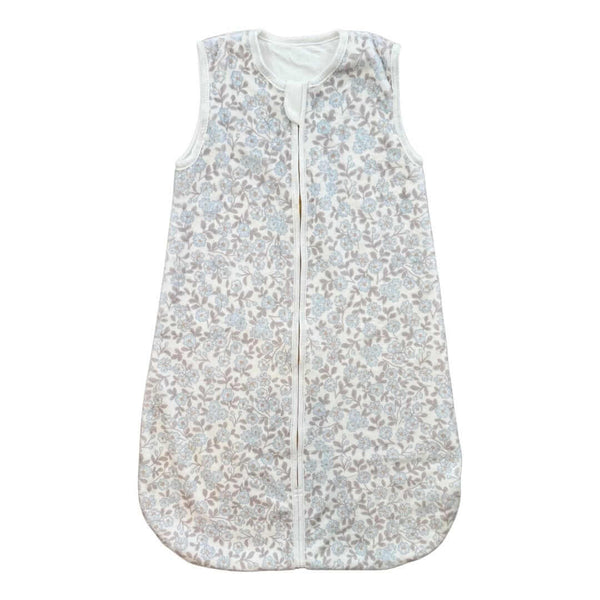 Sleeveless baby sleep sack with a soft floral print in light blue and taupe tones.