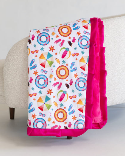 Colorful children's blanket with pool-themed patterns on a white surface.