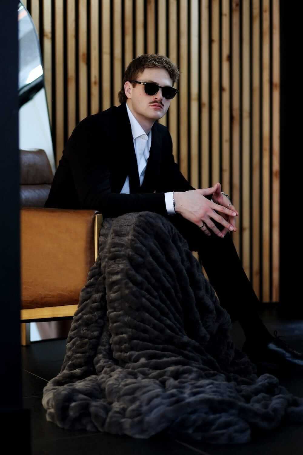 Walker Kessler Biggest Hugs Charcoal Blanket draped over a stylish model in sunglasses, showcasing its oversized comfort.
