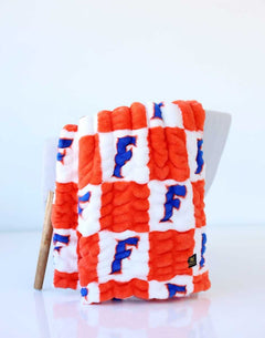 Orange and white checkered Minky Couture Florida Gators blanket with blue F logos.