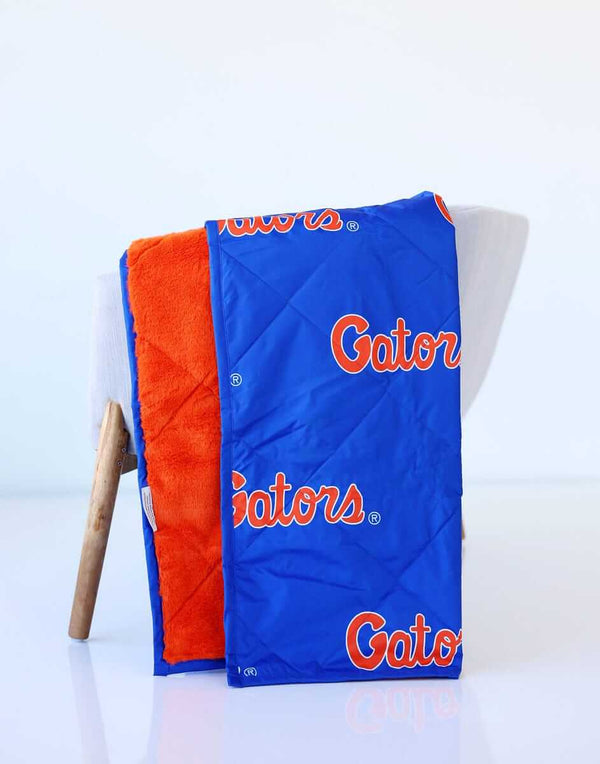 Blue Minky Couture blanket with orange Florida Gators logos and soft orange lining.