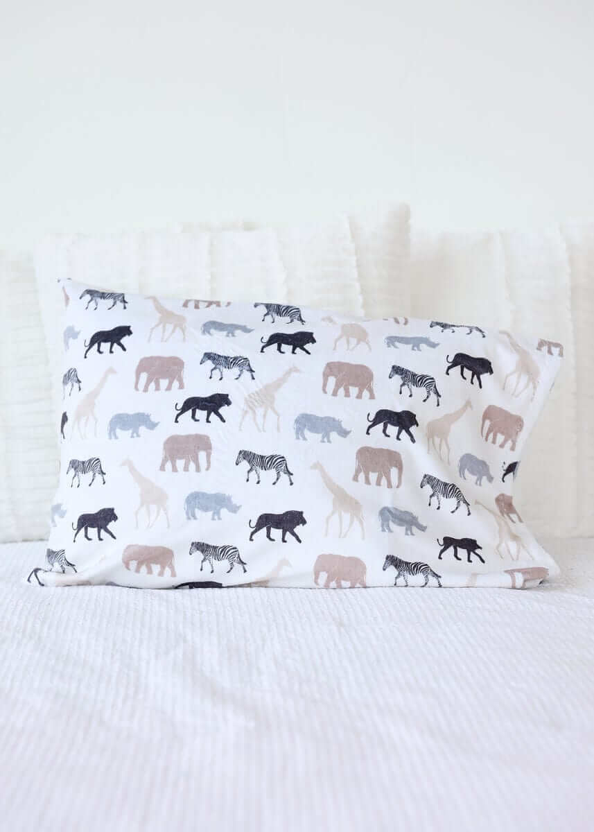 Safari Blanket pillow featuring animal silhouettes in neutral tones on a white background.
