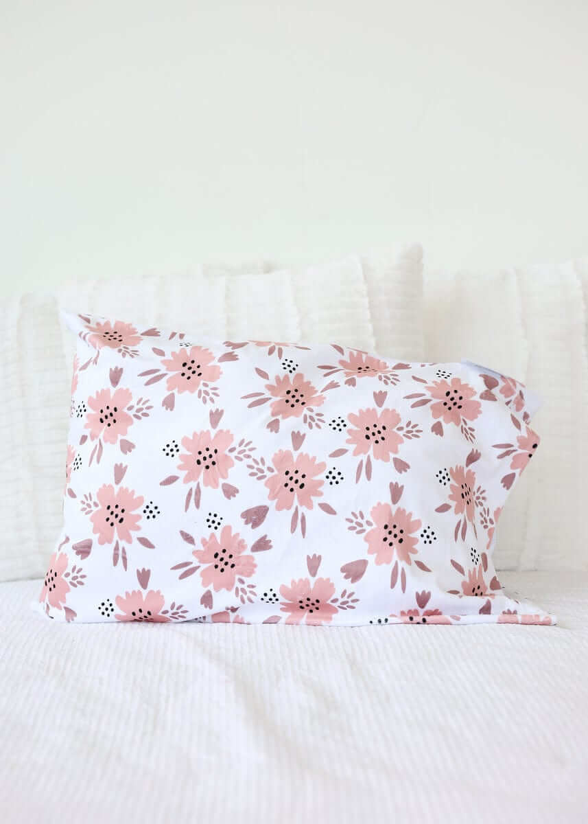 Apricot Blossom Blanket design featuring blush and mauve floral patterns on a pillow.