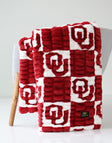 University of Oklahoma Sooners Blanket  draped on a chair, featuring a cozy red and white pattern.