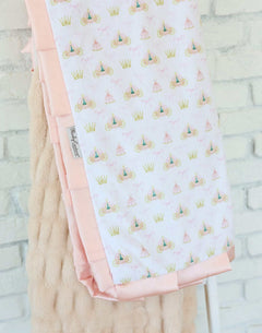Minky Couture Princess Coach Blanket featuring crowns, bows, and royal carriages on a white background with apricot plush backing.