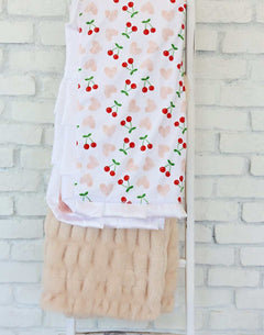 Cheery Cherry Blanket featuring bright red cherry pairs and pink hearts on a white background, with a plush apricot backing.