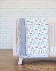 On the Farm Blanket draped over a crib with charming barnyard scenes and a silver plush minky backing.