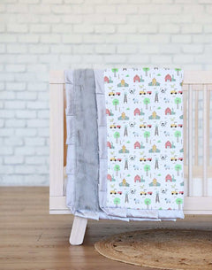 On the Farm Blanket draped over a crib with charming barnyard scenes and a silver plush minky backing.