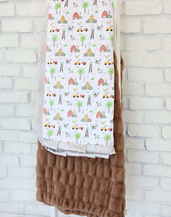 On the Farm Blanket featuring farm scenes with barns, tractors, and a plush backing for cozy comfort.