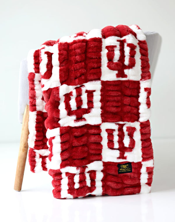 Hugs Indiana University Hoosiers Blanket draped over a chair, featuring a red and white design with IU logo.