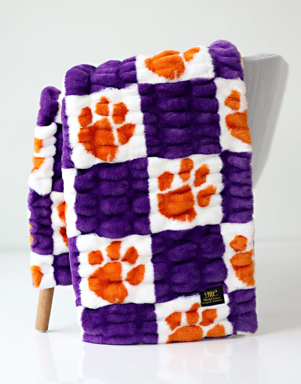 Clemson University Tigers Blanket featuring purple and orange paw print pattern on a soft fleece material.