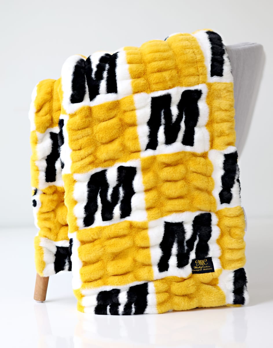 University of Missouri Tigers Blanket, soft textured blanket with black and yellow design on display.
