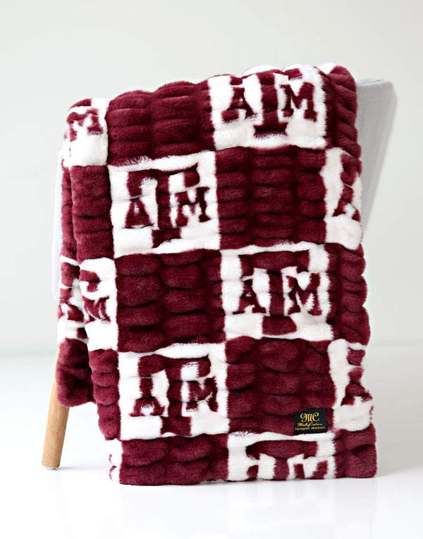 Texas A&M Aggies Blanket featuring a maroon and white design with collegiate logos.