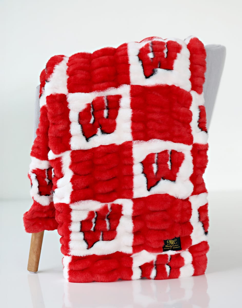 University of Wisconsin Badgers blanket featuring and red and white check pattern with the Wisconsin logo in the white squares.