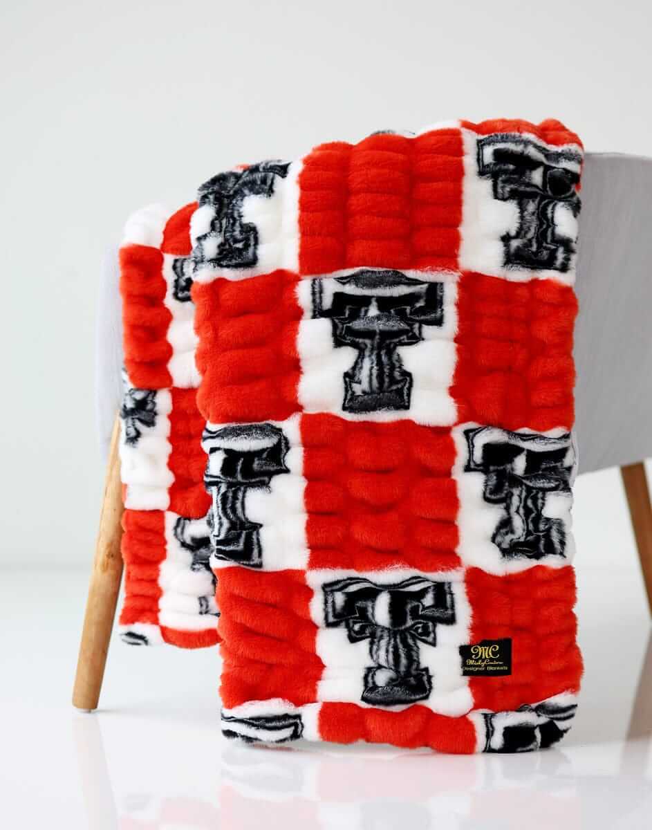 Texas Tech Raiders Hugs Minky Couture blanket on a chair.