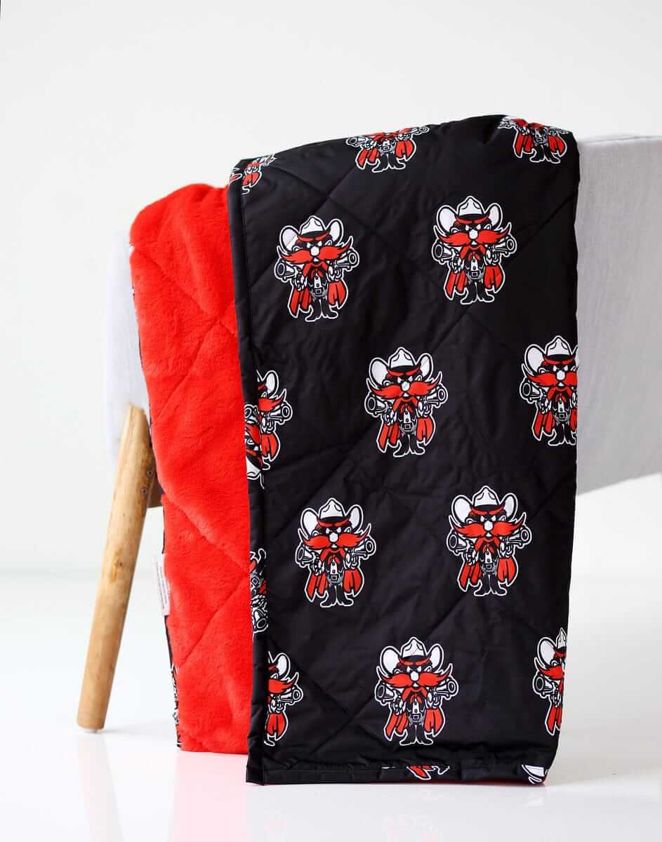 Everywhere Texas Tech Raiders Hooded Stadium Minky Couture blanket folded over a chair.