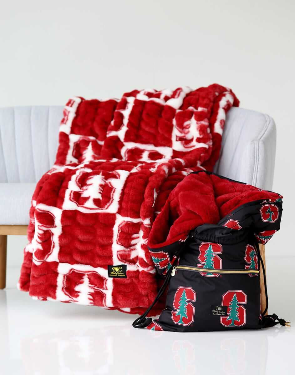 Stanford Cardinals Minky Couture blanket folded over a chair with matching drawstring bag beside it.