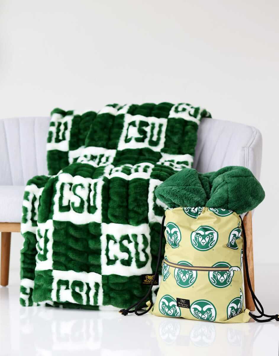 Colorado State Rams blanket on a chair with matching Colorado Rams drawstring bag beside it.