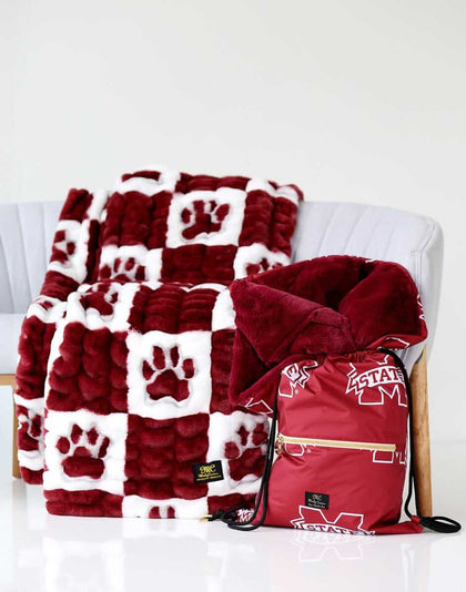 Mississippi State Hugs Minky Couture blanket on a chair with matching maroon drawstring bag beside it.
